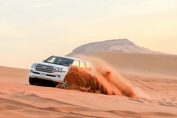 Experience the thrill of 4x4 dune bashing across the stunning desert landscape with captivating views at sunset and create unforgettable memories during an exhilarating evening in Dubai.